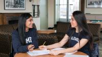 Students talking at a table at the Bard Hall 11th floor lounge